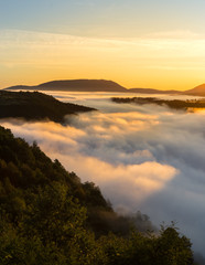 Cloud inversion viewed from top of the hill during warm morning sunrise
