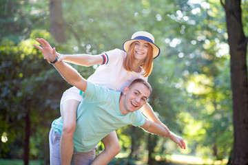 Happy young couple boyfriend and girlfriend having fun outdoors in summer park.