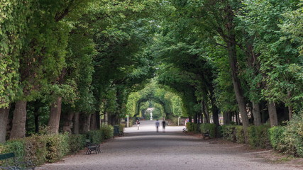 Tourists walking in park alley timelapse next to Schonbrunn Palace, imperial summer residence in Vienna, Austria.