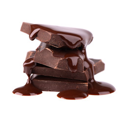 Chocolate pieces stack and chocolate syrup isolated on white background. Close up.