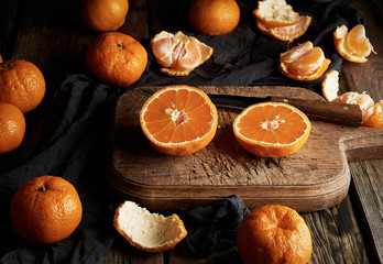 ripe round tangerines and cut in half on an old vintage cutting board