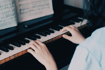 A woman playing piano in her room