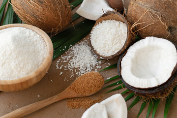 fresh half cut and whole coconuts with coconut flakes on background