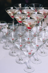 Wine glasses and martini glasses, wines stand in a row on the bar counter. Glass glasses with alcohol stand on top of each other. Photography, concept.