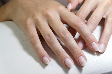 Hands of a client with manicure before applying a gel base close-up.
