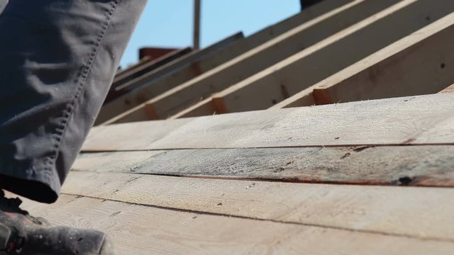 roofer working on roof structure of building on construction sit