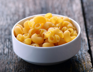 macaroni in white bowl on vintage wooden table