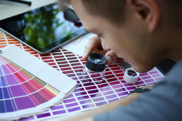 Male serviceman hold in hand magnifying glass making colour test