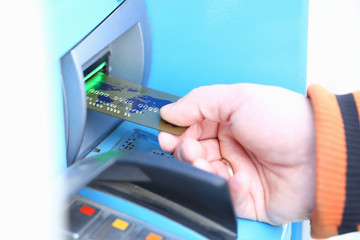 Male hand hold credit card aganist ATM