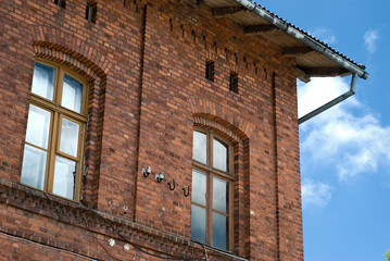 Fragment of the historical building. Masonry brickwall, window and roof