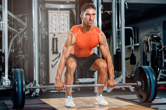 Athletic Men Preparing To Do Barbell Dead Lift In The Gym