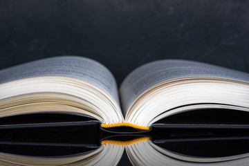 Open book with reflection on table close-up