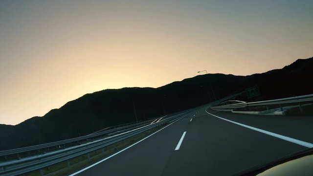 Sport fast pov driving on empty asphalt highway road and sunset sky backgroung