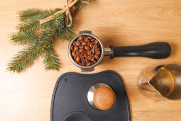 Coffee beans in portafilter, tamper and tree branch. Accessories for the professional preparation of coffee top view