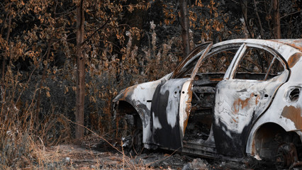 Abandoned car. Passenger car after a strong fire. Place next to a burnt car. A lot of rubbish, singing and metal parts. The concept of a traffic accident and vandalism or crime. 4k