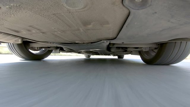 Sport automobile driving fast on aspalt road, view from below