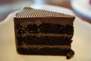 Chocolate cake, cheesecake with strawberry jam and hot chocolate beverage in a cafe.