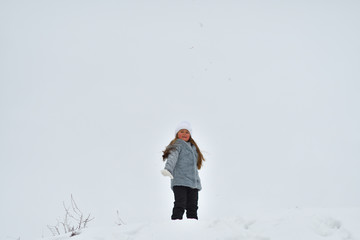 Happy child girl on winter walk outdoors . little child playing in winter holidays. Girl in winter lake