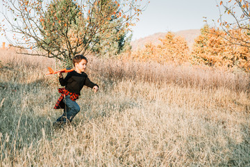 Boy playing with red plane toy in the park. Children activity