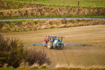 farmer spreading fertilizer or pesticides in the fields