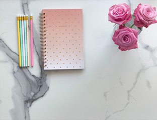Beautiful notebook with pencils and flowers on marble background - flat lay