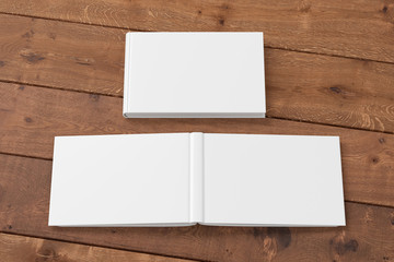 Blank white horizontal closed and open and upside down book cover on wooden boards isolated with clipping path around cover. 3d illustration
