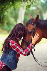 Obraz premium girl with long hair hugs horse