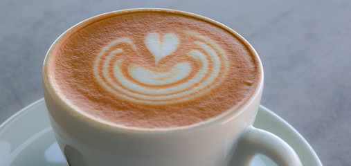 Apetitoso café servido en una taza blanca, con y una bella imagen dibujada en la superficie - obrazy, fototapety, plakaty