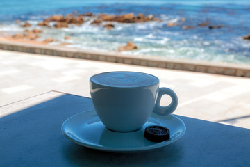 Apetitoso café servido en una taza blanca, con y una bella imagen dibujada en la superficie - obrazy, fototapety, plakaty