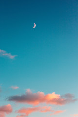 small clouds and a month against the evening turquoise sky