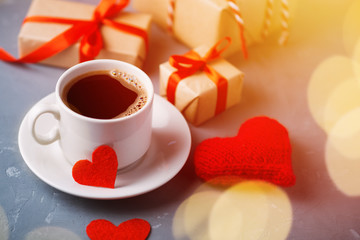A white Cup of espresso in the morning and gifts and red hearts for Valentine's day. Symbol of love