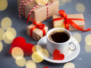 A white Cup of espresso in the morning and gifts and red hearts for Valentine's day. Symbol of love