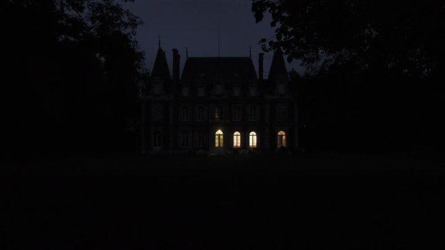 establishing shot of haunted old scary creepy castle at night