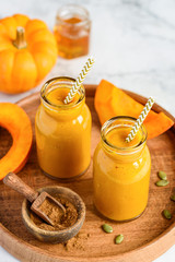 Pumpkin smoothie in bottles on a wooden tray. Healthy eating. Vegetarian food. Selective focus