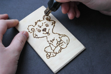 The process of pyrography.  Picture with a bear on a board 