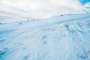 Fototapeta na wymiar scenic view of snowy mountain in white fluffy clouds