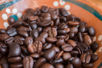 Acercamiento a granos de café en plato de barro