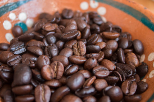 Acercamiento a granos de café en plato de barro