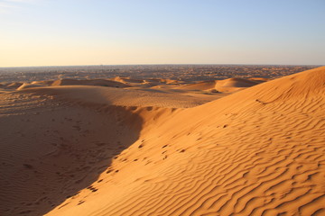 Fototapeta na wymiar sand dunes in the desert with snadows in the evening light