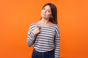 This is me! Portrait of proud young woman with brown hair in long sleeve striped shirt standing,...