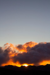 Mountain silhouette with clouds at sunrise time.