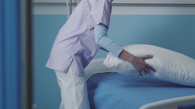 Expert nurse making the bed at the hospital
