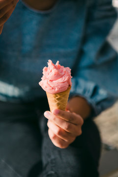 Close up woman eating pink ice cream cone