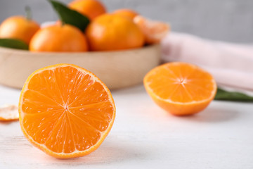 Cut fresh ripe tangerines on white wooden table