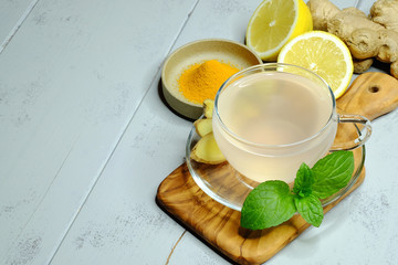 Ginger tea, curcuma, mint and lemon on wooden background