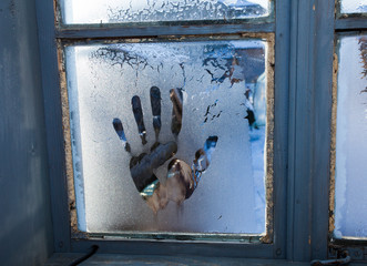 hand print or shape in old frozen window, ice cold scene