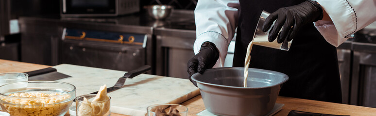 panoramic shot of chocolatier pouring milk into bowl