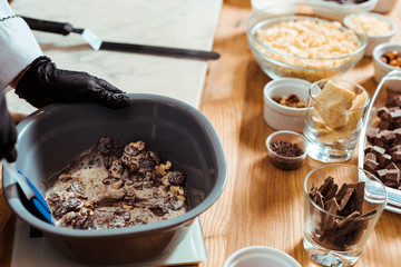 cropped view of chocolatier mixing chocolate chips in bowl