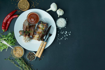 Baked ribs in white b. Grilled pork ribs with spices and fresh herbs. Dark background. Space for text. Table background menu.