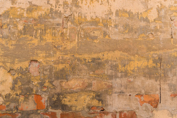 Detailed texture. Old yellow plastered brick wall close-up